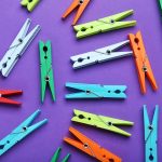 Plastic clothespins on a purple background