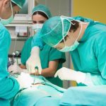 Surgeons working with a scissors on a patient