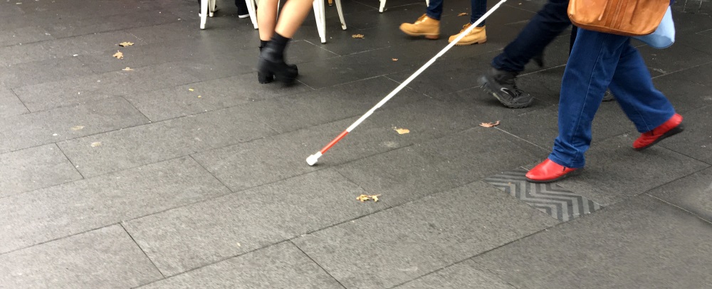 Visually impaired person walks in the street
