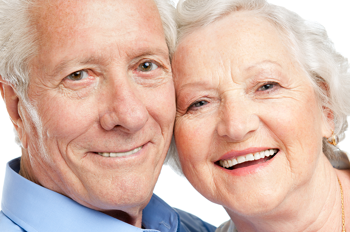 Smiling satisfied senior couple looking together at camera closeup