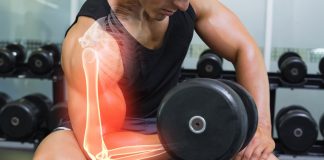 Highlighted arm of strong man lifting weights